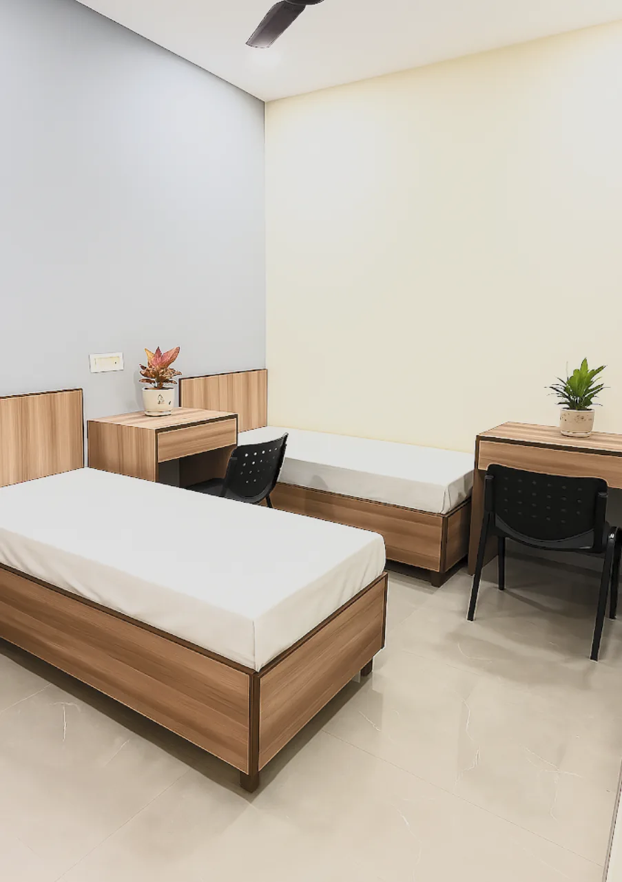 Bright twin-sharing room with two beds and separate study desks.